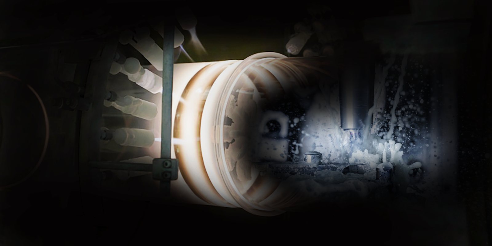 A fused quartz tube glowing on the lathe during flame working, with coolant spray at the tool.